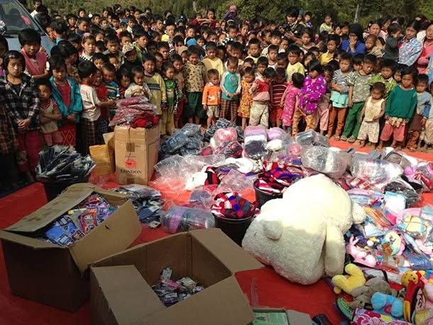 Children gathered around donated supplies at a community distribution